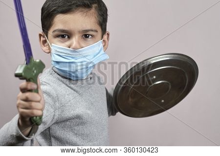 Bored Boy In Medical Face Mask Plays Knight Cavalier. Little Moddle-eastern Kid In Surgical Masks Ha