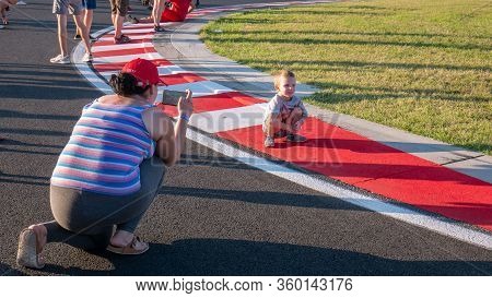 Mogyorod Hungary 08 01 2019: Mother Photographs Her Son On The Red And White Sidewalks Of The Motor 