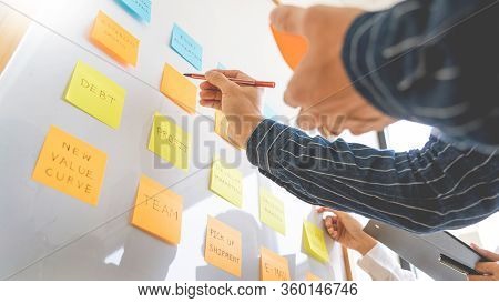 Young Business Workers Posting With Sticky Notes Stickers Reminders  Creative Brainstorming At Board