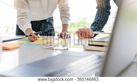 Young Business Workers Posting With Sticky Notes Stickers Reminders  Creative Brainstorming At Board