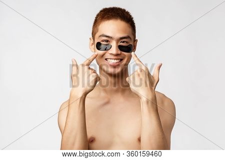 Beauty, People And Lifestyle Concept. Portrait Of Pleased, Handsome Smiling Asian Man Apply Eye-patc