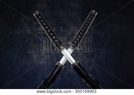 Two Crossed Katanas With Partially Drawn Blades