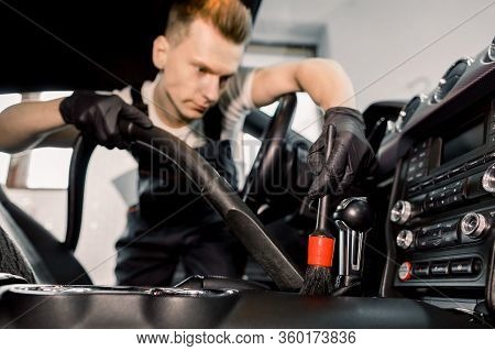 Close Up Of The Process Of Removing Dust With A Vacuum Cleaner And Brush During Car Interior Cleanin