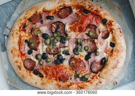 Big Round Hot Pizza With Hum, Sausage,cucumber, Olives Onion And Cheese Close Up Photo