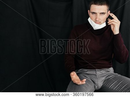 Man Sitting And Putting On The Protective Medical Mask On His Face