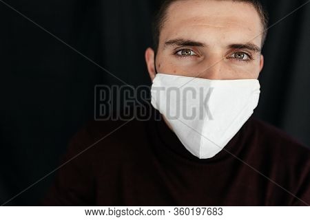 Serious Man In The Protective Medical Mask On The Black Backgroun