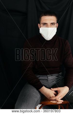 Serious Man In The Medicine Mask Sitting With His Arms Crossed