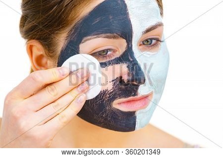 Woman With Clay Carbo Black Mask On One Half Face And White Mud On Second Half. Girl Removing Cosmet