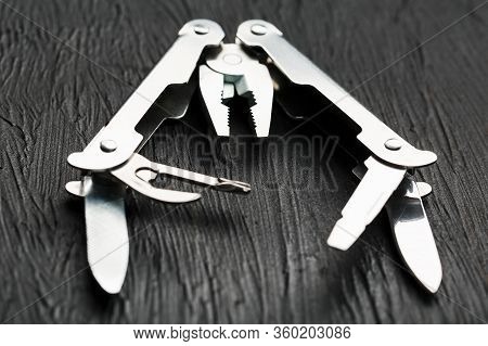 Multi-functional Tool On A Black Textural Background.