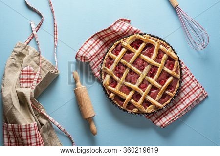 Raspberry Pie In An Oven Tray On A Blue Kitchen Counter. Baking Raspberry Pie Concept. Apron And Coo