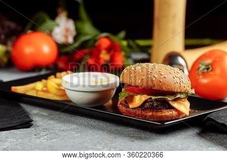 Burger With Cutlet, Cheese And Tomatoes. With French Fries And Burger Sauce