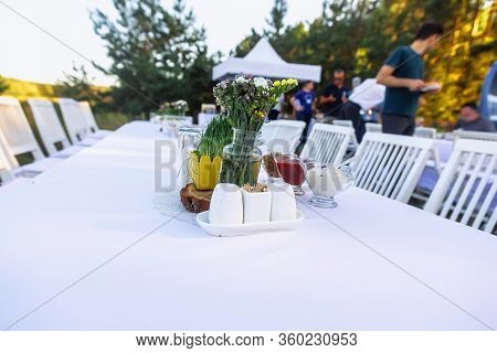 Flower Bouquet And Sauces On Table On Nature Picnic Katerring