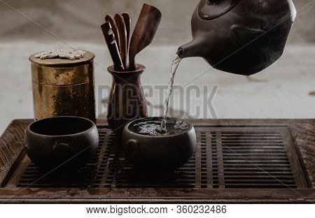 Cropped Shot Of Woman Pouring Tea In Traditional Chinese Teaware