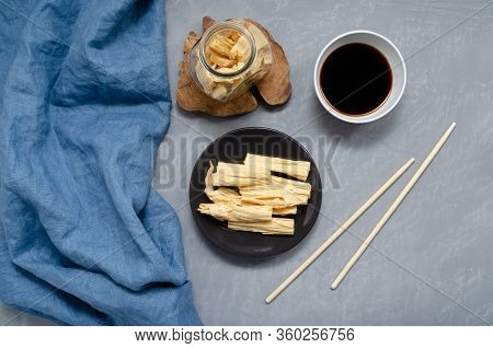 Space For Text. Fermented Soy Tofu Yuba Skin With On A Brown Plate And In A Jar On A Gray Neutral Ba