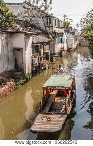 Suzhou China - May 3, 2010: Brown Wooden Taxi Sloop With Red Lantern And Captain On Brown Water Cana