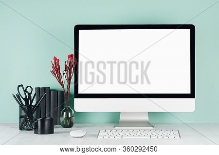 Simple Office Interior With Blank Computer Monitor, Black Stationery, Books, Red Flowers, Keyboard, 