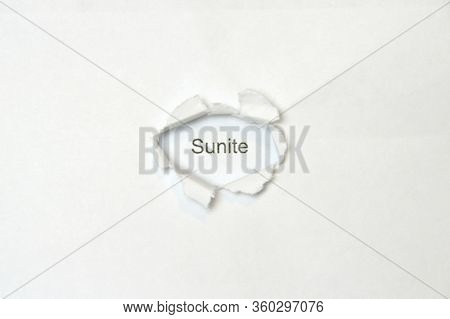 Word Sunite On White Isolated Background, The Inscription Through The Wound Hole In The Paper. Stock