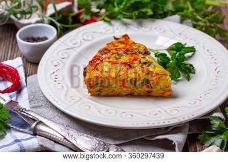 Piece Of Vegetable Kugel From Zucchini, Carrots, Potatoes, Garlic And Turmeric In A White Plate, Sel