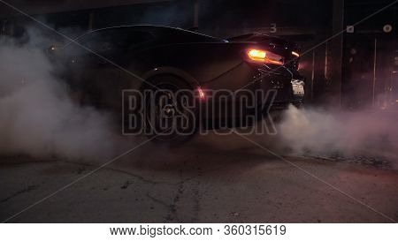 Tomsk, Russia - March 30, 2020: Chevrolet Camaro Zl1 The Exorcist Burns Rubber At Night Near Buildin