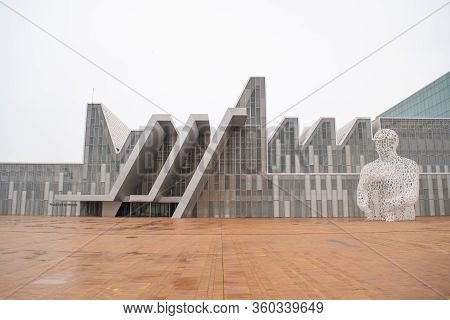 Saragossa, Spain - February 6, 2018: Facade of the Zaragoza Conference Center and white sculpture made of letters called Alma del Ebro on a rainy day with wet floors.