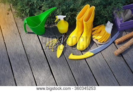Gardening. Spring Garden Works Background. Garden Tools And Rain Boots On The Weathered Wooden Terra