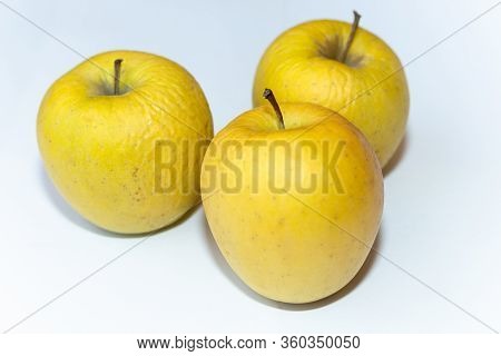 Several Old Dried Yellow Apples On A White Background