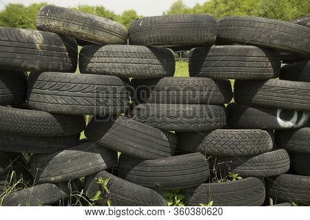 Old Tires Stacked To Form A Barricade Or Wall At A Fairground To Provide A Safety Feature For Partic