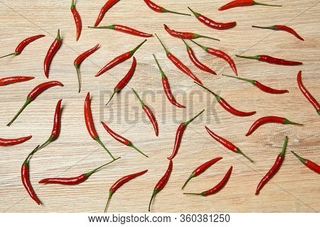 Background - Pods Of Red Chili Pepper Evenly Spread On A Wooden Surface