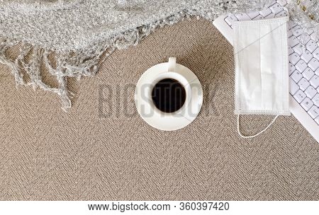 A Cup Of Coffee, A Keyboard, Plaid And A Medical Mask Are On The Sofa. Self-isolation, Quarantine, S