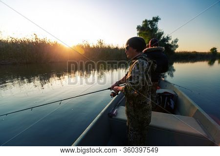 Anglers fishing from the boat on the calm river in Astrakhan Region in Russia. Astrakhan is a famous fishing destination