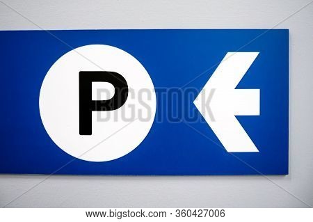 Blue Parking Sign With White Arrow And Black Capital P On White Background