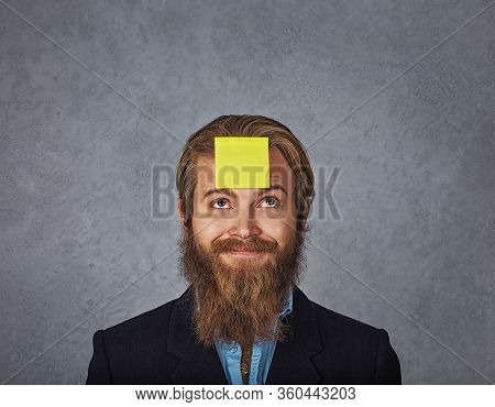 Bearded Smiling Business Man Looking Up To The Sticker Stick On His Head Forehead