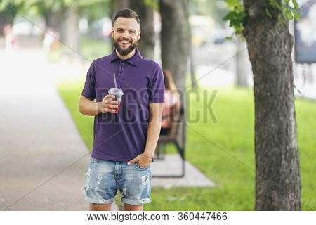 A Young Guy Walking In The Park With Lemonade In The Spring. Spring Day.