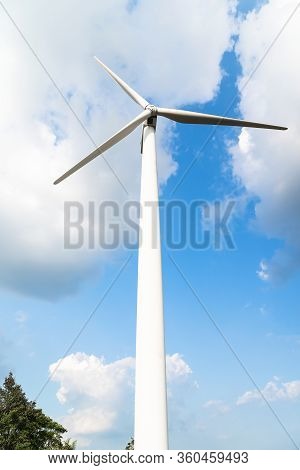 Wind Turbine Against A Cloudy Blue Sky