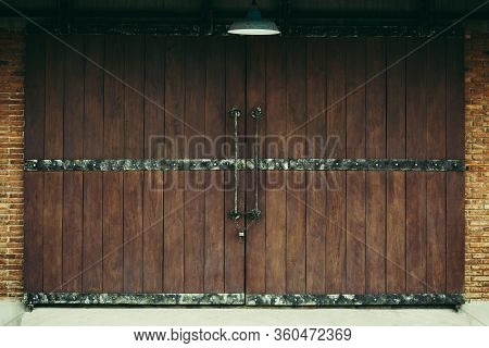 Old Warehouse As Dark Brwon Wooden Sliding Door With Brown Brick Wall And Lamp