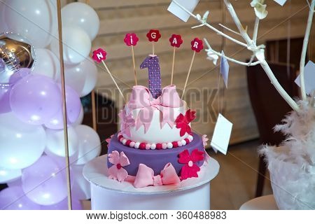 Nigar Inscription With Candles . A Purple Inscription. A Wet Birthday Cake.