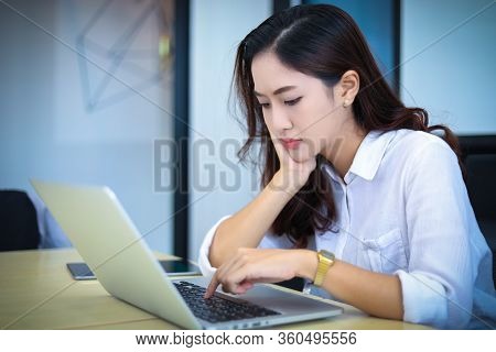 Asian Business Women Using Notebook And  Serious And Headache For Working