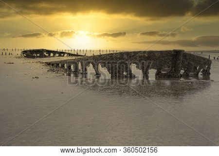 A Special Picture Of The Wreck Of Wierum With Spectacular Clouds, The Wadden Sea In Spring Condition