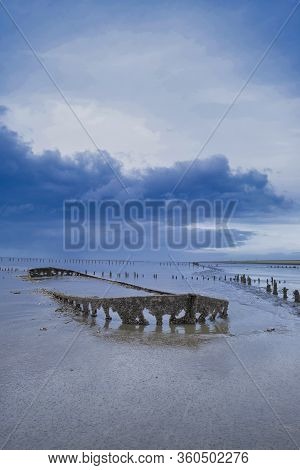 A Special Picture Of The Wreck Of Wierum With Spectacular Clouds, The Wadden Sea In Spring Condition
