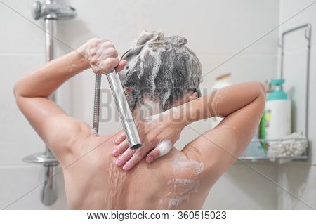 Woman Washes Her Hair With Shampoo In Bathroom. Woman Washing Her Hair With A Lot Of Foam Inside A S