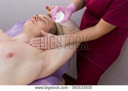 The Beautician Applies A Disinfectant Solution To The Mans Armpits Before The Depilation Procedure W
