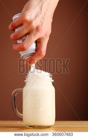 Milkshake Making On Wooden Table Closeup. Process Of Topping And Decorating Milkshake. Desset With C