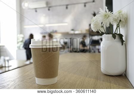 Mock Up With A Cup Of Coffee. A Glass Is On The Table In A Cafe, Selling Coffee In The Background. C