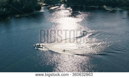 People Kayaking And Wake Boarding With Fast Boats On The River