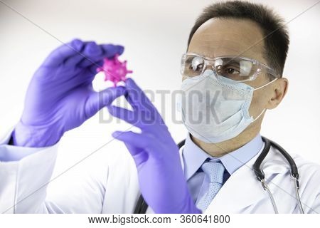 Male Middle Age Lab Technician Assistant In Medical Uniform, Protective Mask And Glasses Looking At 