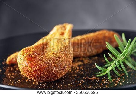 Seasoned Chicken With Hot Sauce And A Sprig Of Rosemary