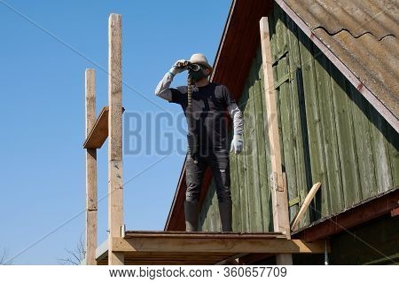 Man Looking Through Binoculars In A Tower, Wearing A Protection Face Mask, In Coronavirus Covid-19 P