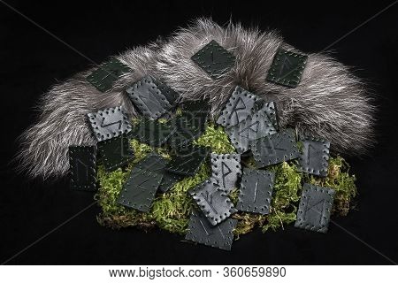 A Set Of 24 Green Leather Norse Runes On A Background Of Fur And Moss.