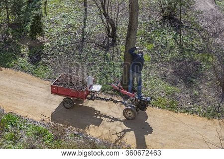 Old Walk-behind Tractor With A Trailer In The Park