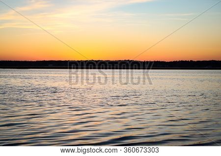 Beautiful Landscape View With River Slowly Flowing With Small Waves During The Sunset. Photo Taken I